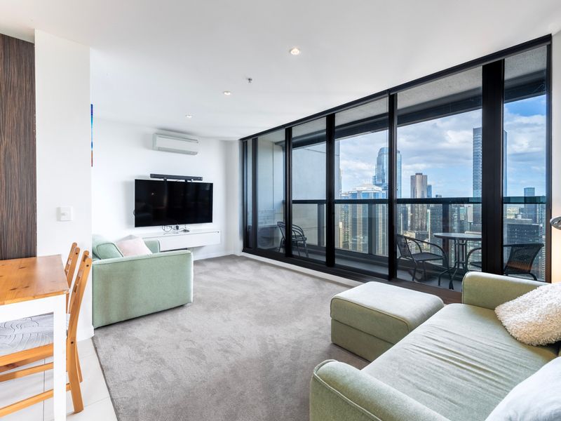 Bright living area with floor-to-ceiling windows and skyline views