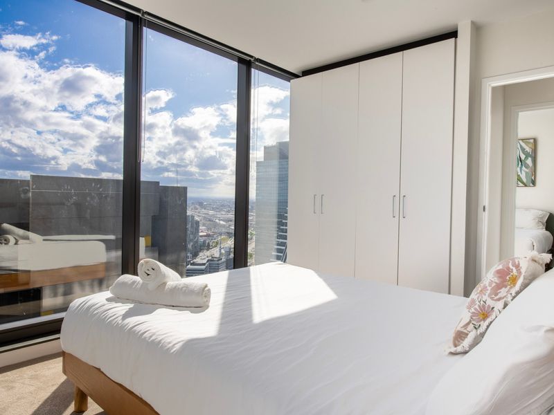 Sunlit bedroom with mirrored wardrobe and balcony access