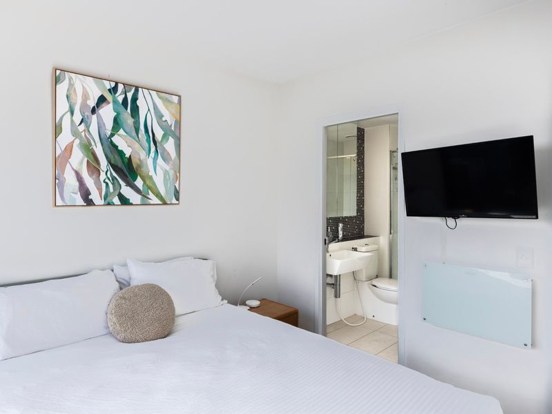 Bedroom with wall-mounted TV and calming tones