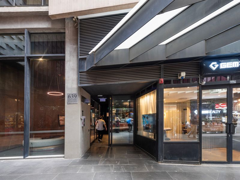 Secure building entrance with café and shops nearby