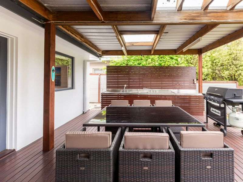 Covered outdoor dining area with BBQ.