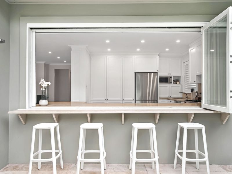 Kitchen servery window opening to outdoor bar seating