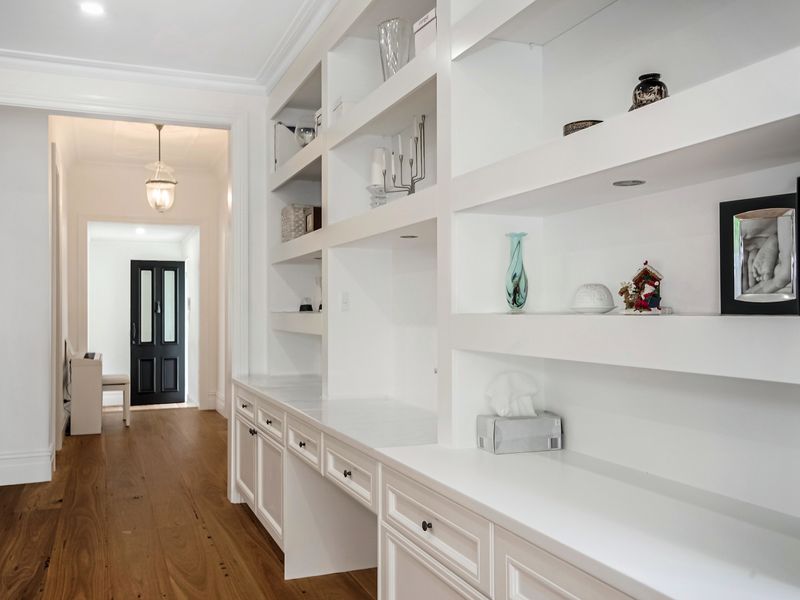 Hallway with elegant built-in shelving and storage