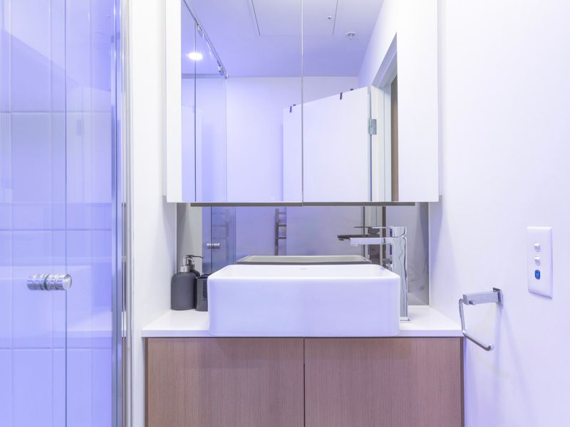 Bright and spotless bathroom with a large mirror and fresh towels.