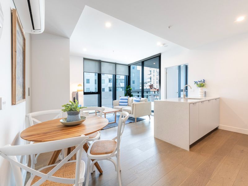 Dining area bathed in sunlight, seamlessly connecting to the kitchen.