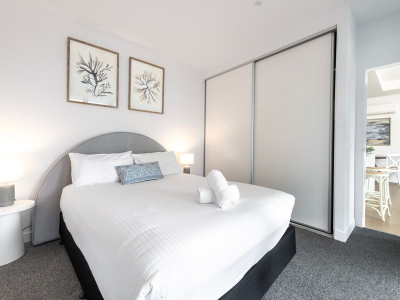 Detailed view of stylish bed setup with decorative cushions.