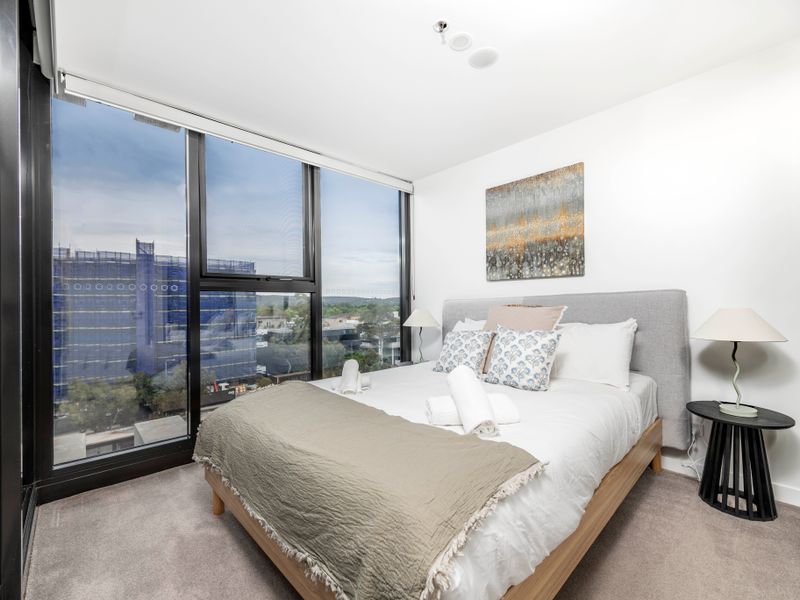 Bright bedroom with floor-to-ceiling windows and relaxing city views