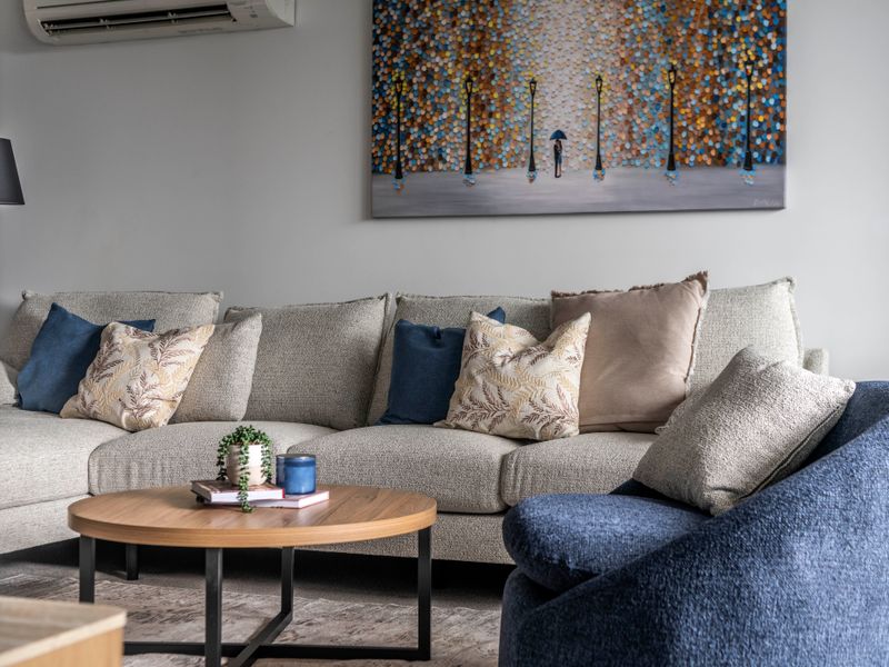 Elegant seating area with soft cushions and colorful artwork.