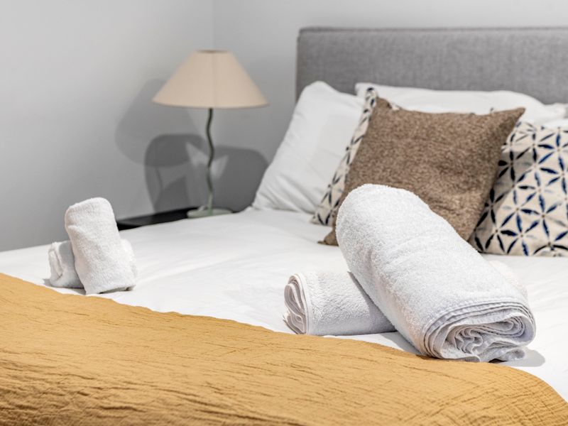 Comfortable bed prepared with fresh towels.