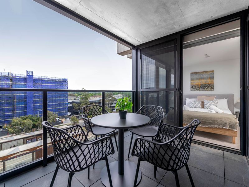 Private balcony with outdoor dining set and city views.