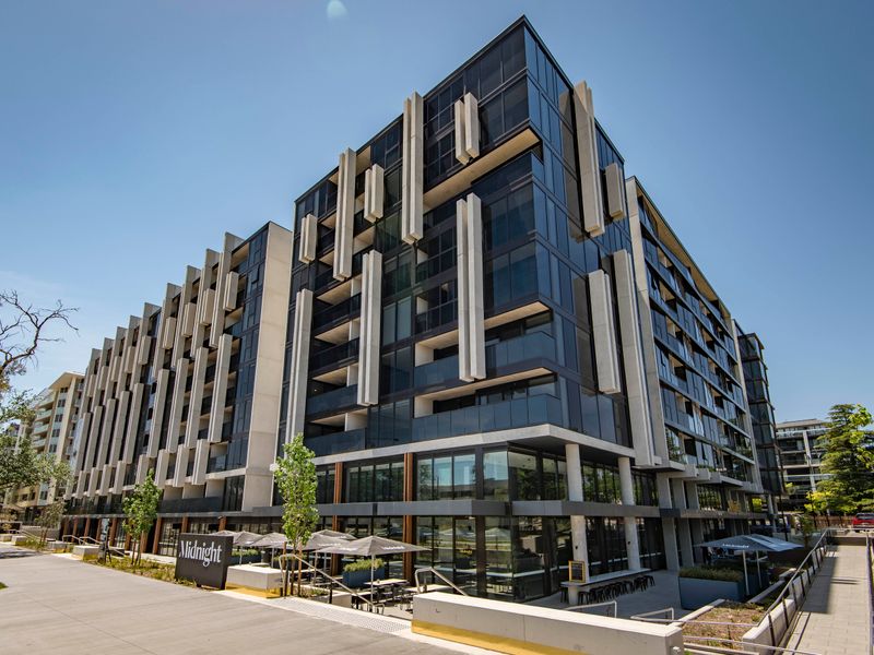 Vibrant mixed-use complex featuring cafés, shops, and tree-lined walkways