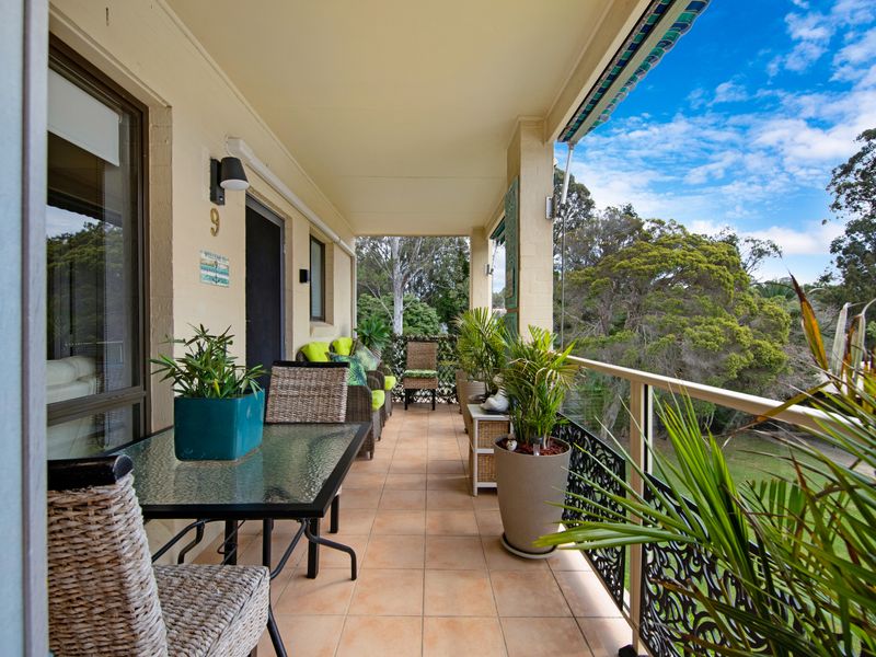 Balcony with outdoor seating overlooking the garden.