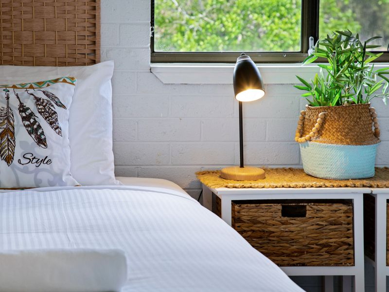 Cozy bedroom corner with soft lighting and woven accents.