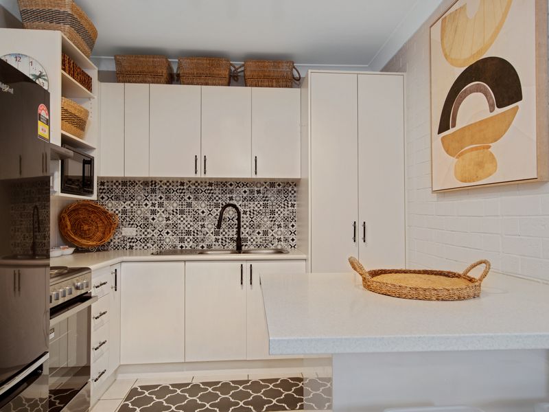 Contemporary kitchen with tiled splashback and modern finishes.