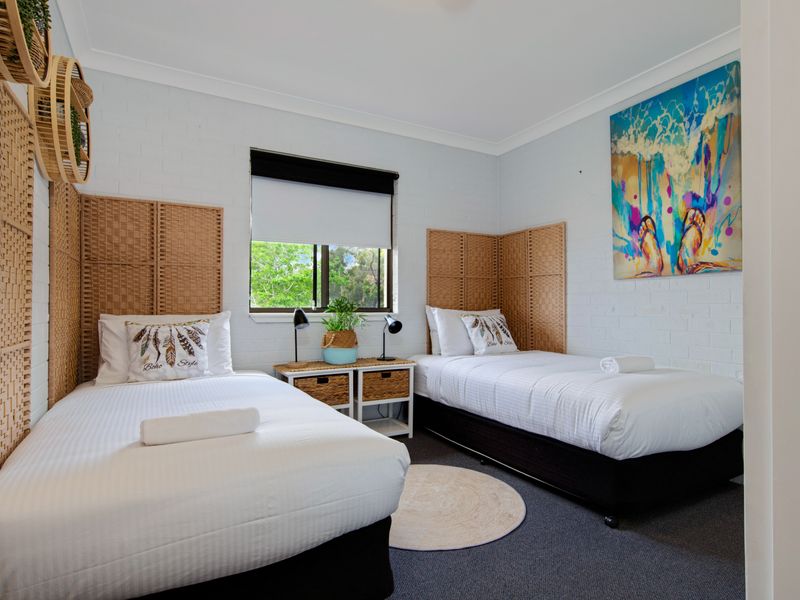 Twin bedroom with large windows and relaxed beach décor.