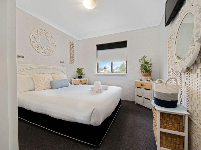 Main bedroom with queen bed and calming neutral tones.