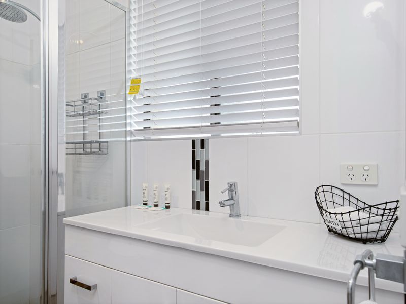 Bright bathroom with walk-in shower and modern fixtures.