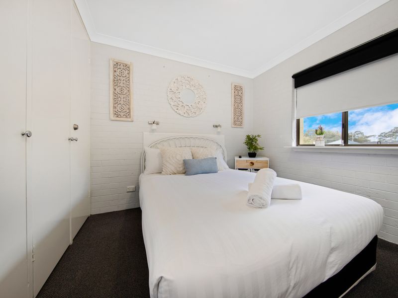 Spacious bedroom featuring coastal artwork and natural textures.