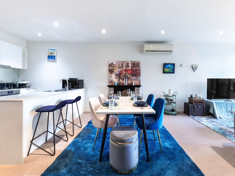Open-plan living and dining area with stylish blue accents and plenty of natural light.