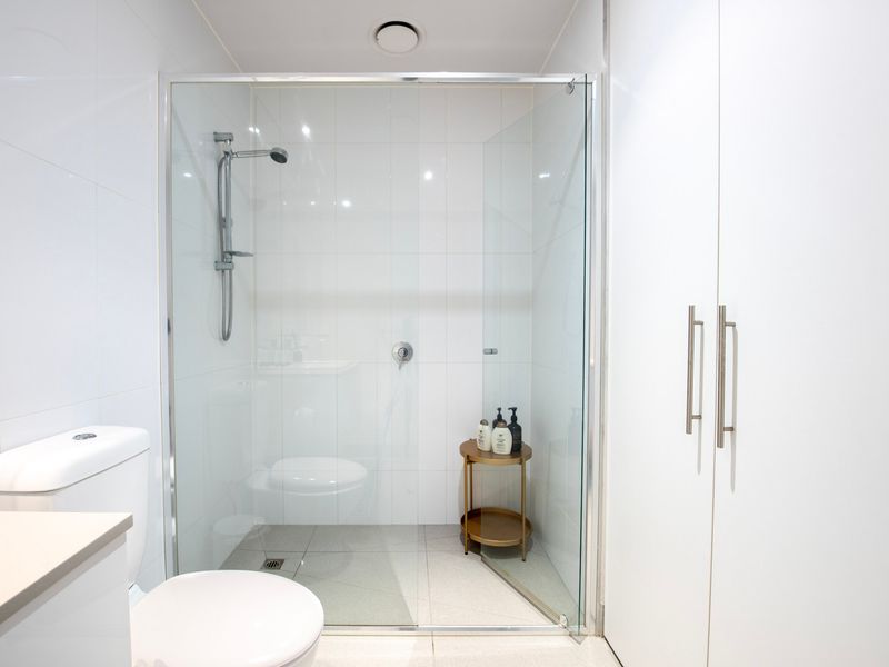 Spacious shower with glass enclosure and quality fittings.