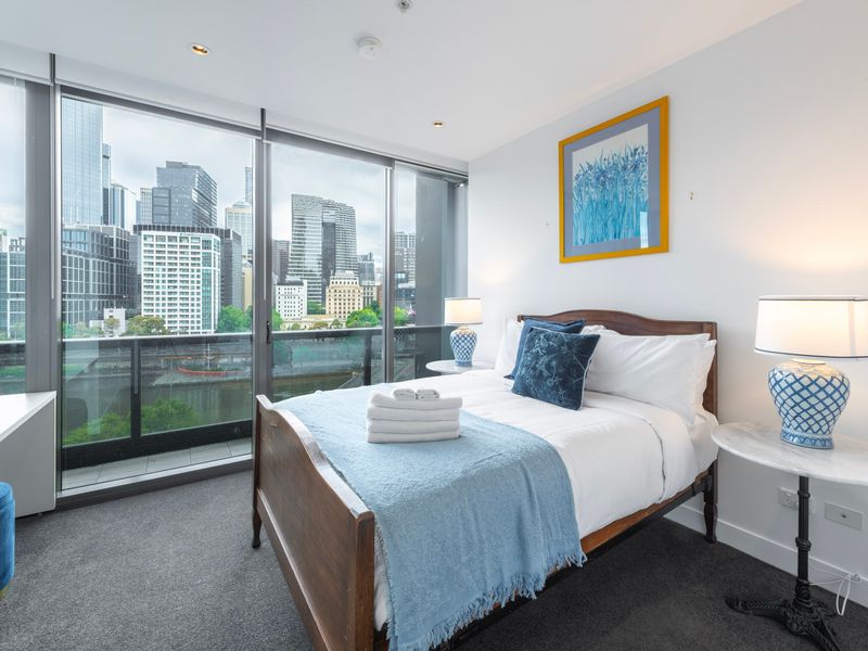 City-view bedroom with warm natural light and modern décor