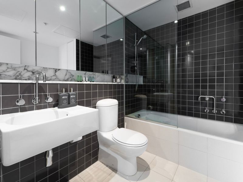 Contemporary bathroom with bathtub and black tile design
