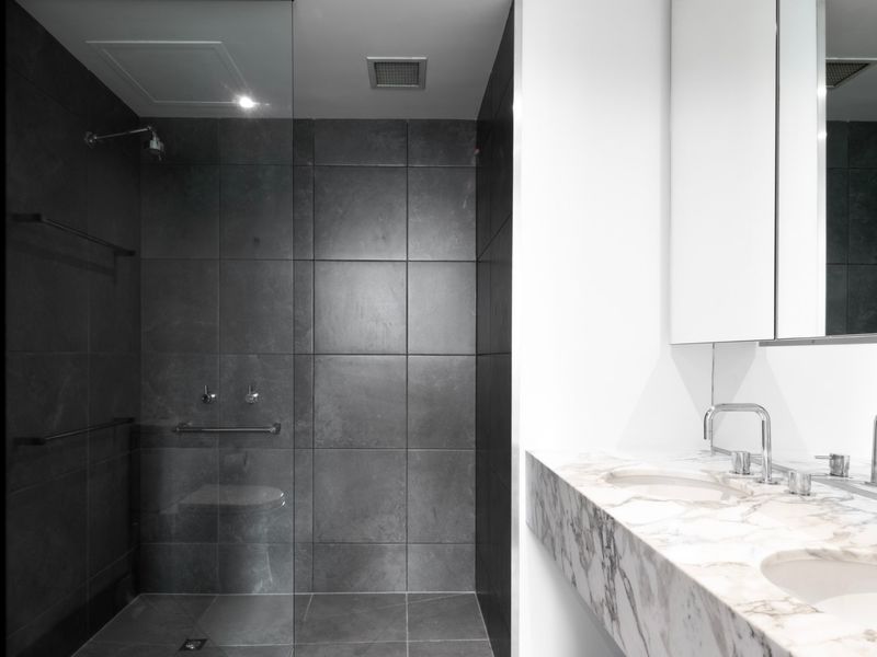 Spacious walk-in shower with sleek black tiles
