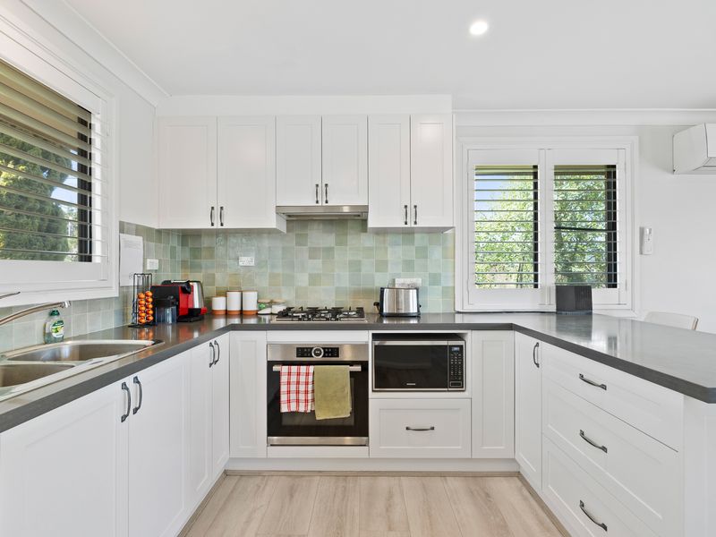 Spacious, fully equipped kitchen with ample storage and leafy window views