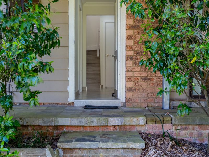 Welcoming front entry framed by greenery