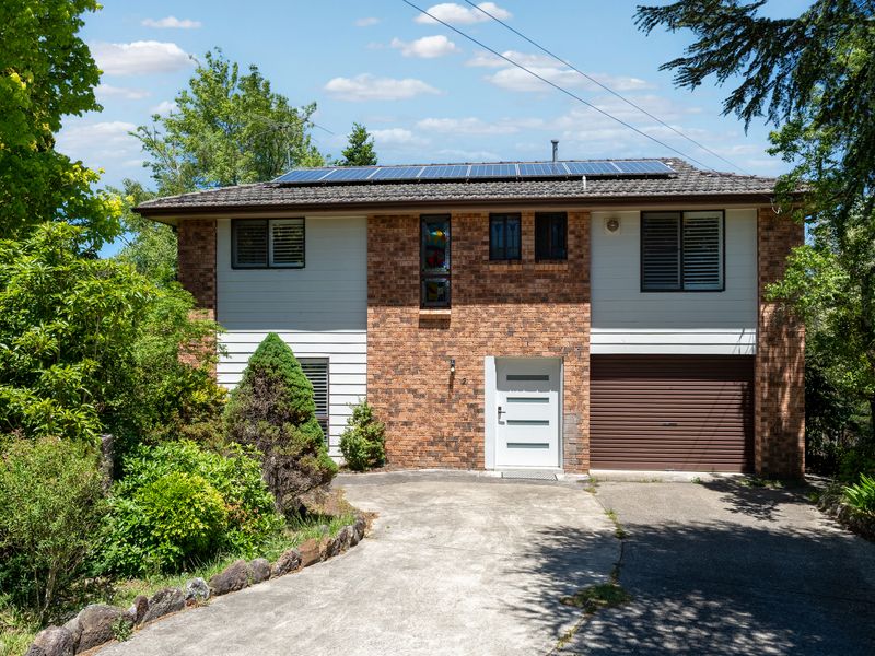 Front exterior with driveway and leafy surrounds