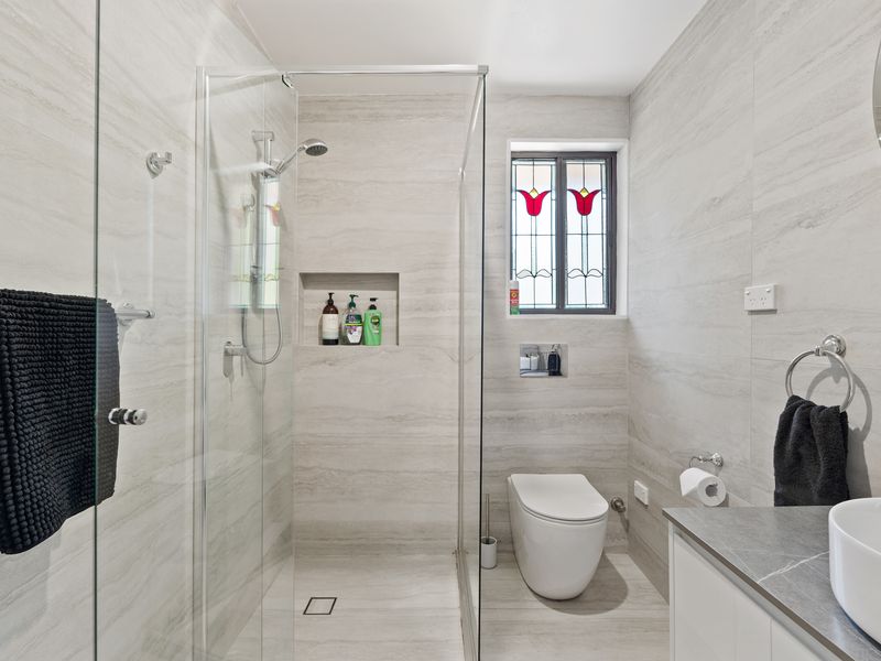 Bright, contemporary bathroom featuring a spacious shower and sleek fittings