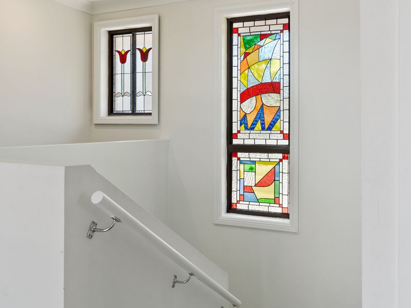 Staircase landing with charming stained-glass window