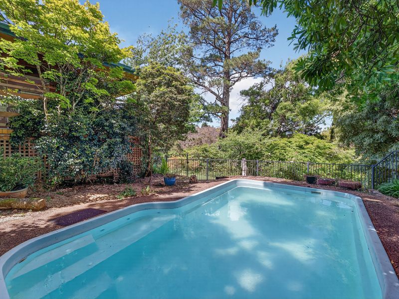 Established garden beds and greenery framing the outdoor pool area.