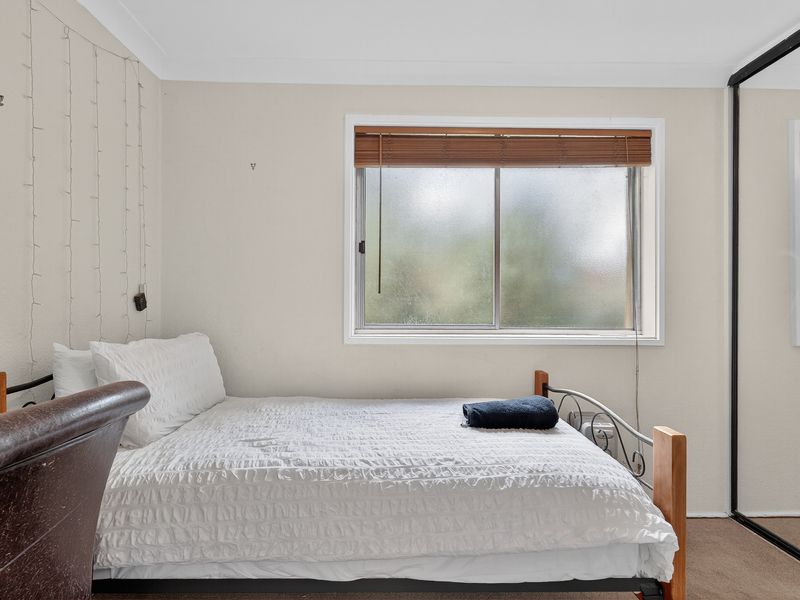 Bright bedroom with a double bed and large window.