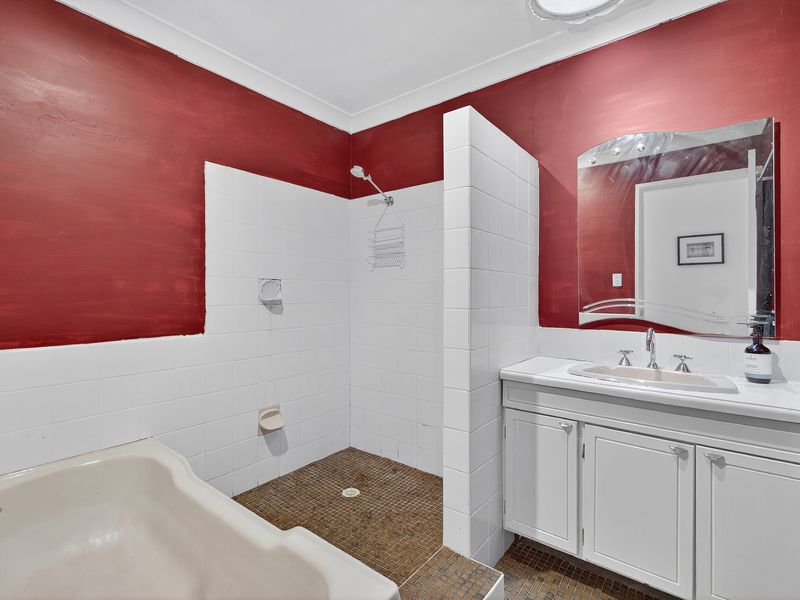 Bathroom close-up showing a red-accented wall and white fixtures.
