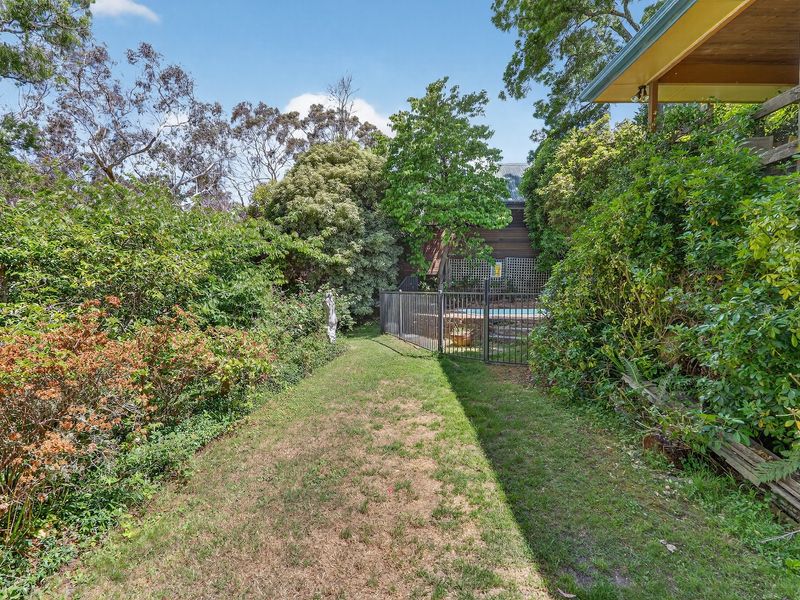 Private garden pathway lined with lush greenery.