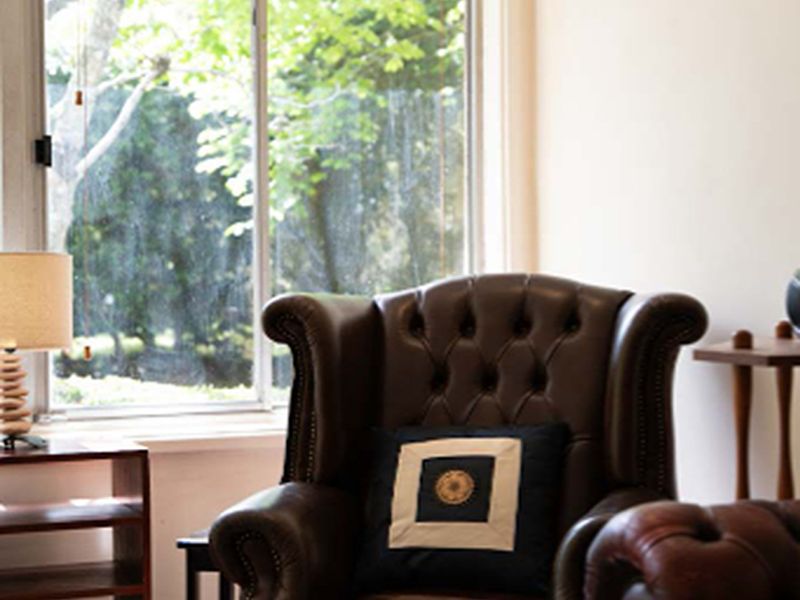 Cozy reading corner with an armchair and window view.