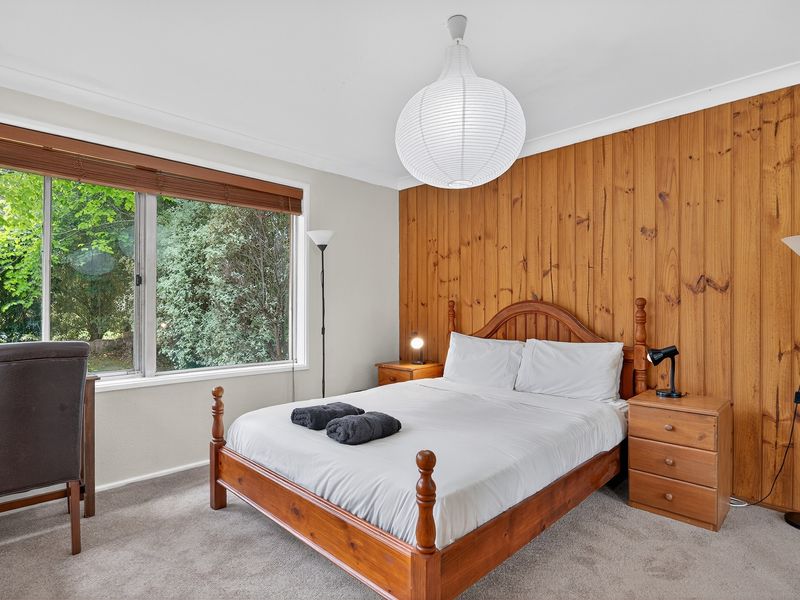 Cozy bedroom with timber accents and peaceful garden views.