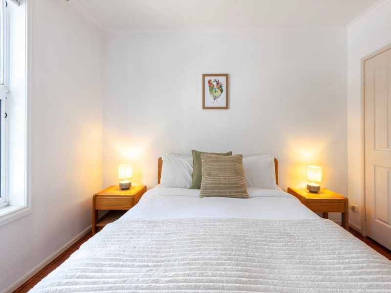 Stylish and serene bedroom with natural light streaming in, offering a peaceful and comfortable retreat.