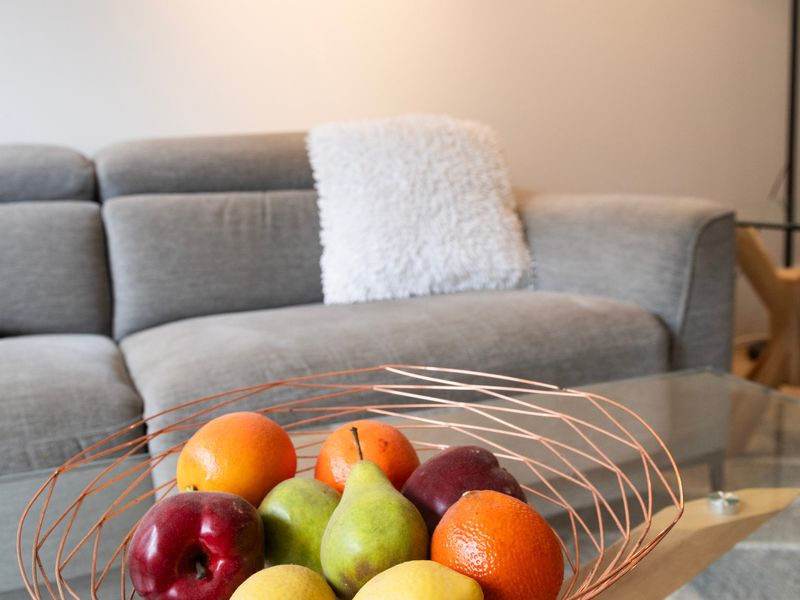Cozy sofa paired with fresh fruit for a welcoming touch.
