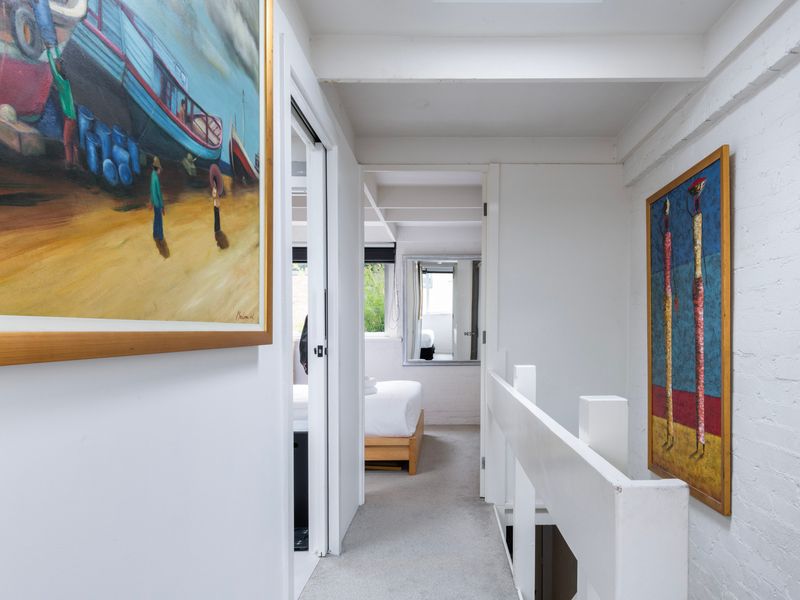 Art-lined hallway leading to the bedrooms and bathroom.