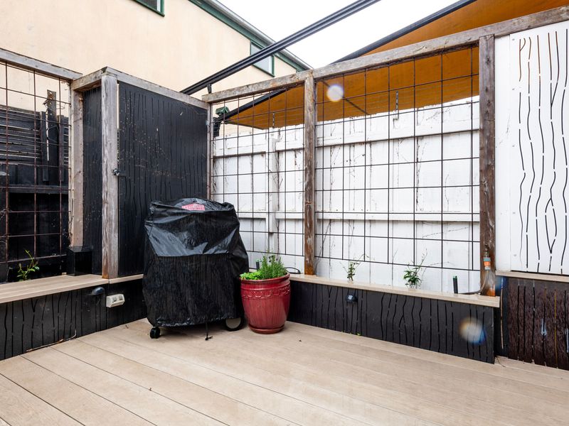 Cozy courtyard corner with BBQ and seating space.