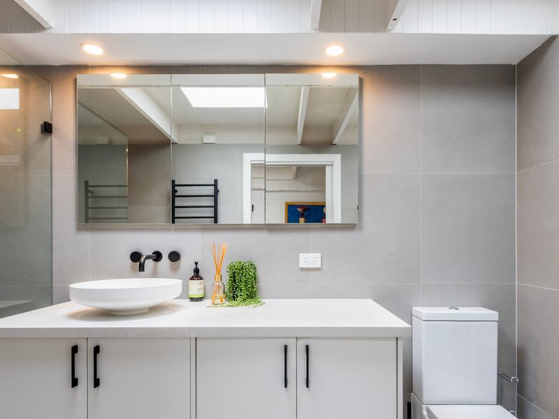 Modern bathroom with skylight and sleek finishes.