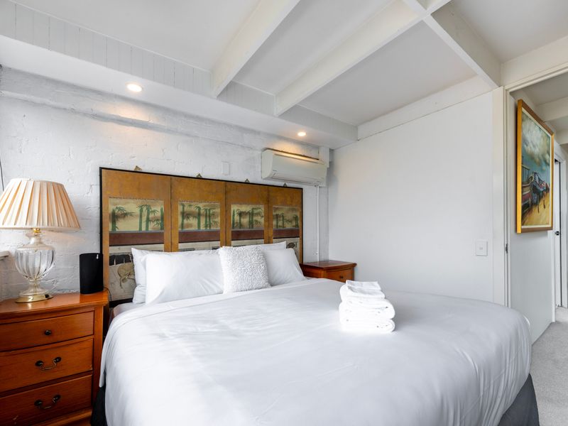 Inviting bedroom with soft lighting and a comfy queen bed.