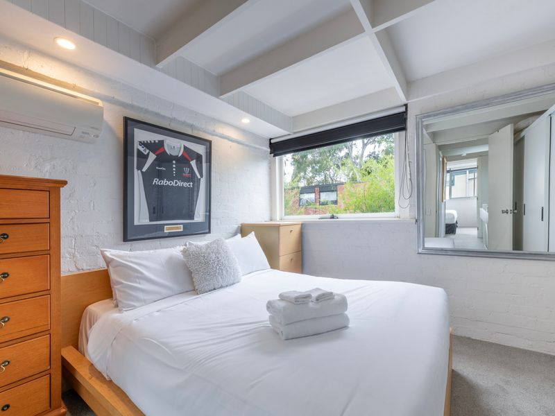 Sunny bedroom featuring crisp linens and corner windows.