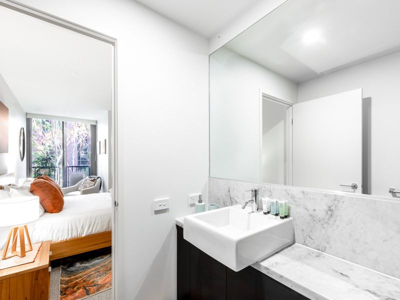 Sleek and bright with spacious vanity and glass shower, ideal for a refreshing start to the day.