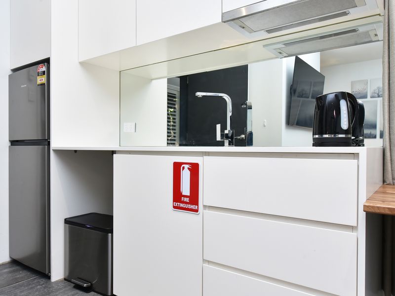 Compact kitchenette area with fridge and tea/coffee setup.