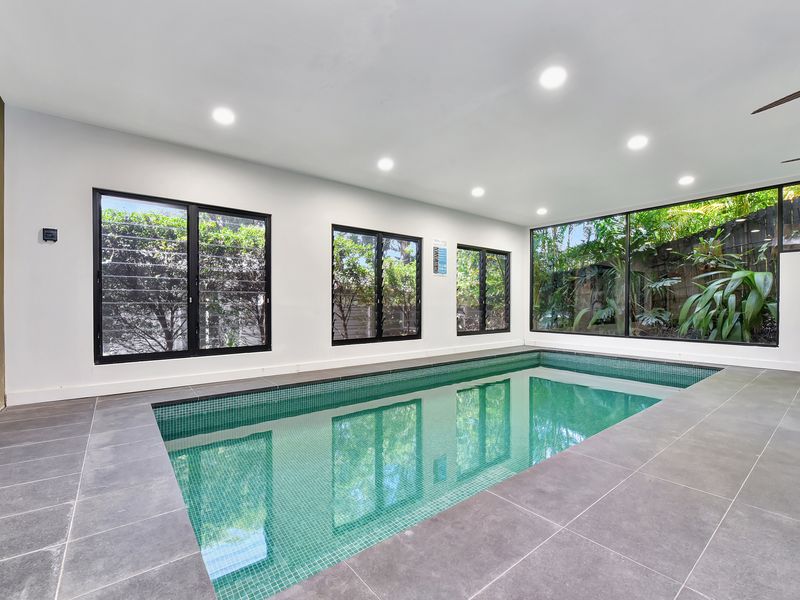 Indoor pool room with large windows and a private, quiet setting.