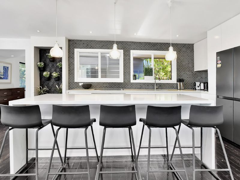 Open kitchen with bar seating and clean contemporary finishes.