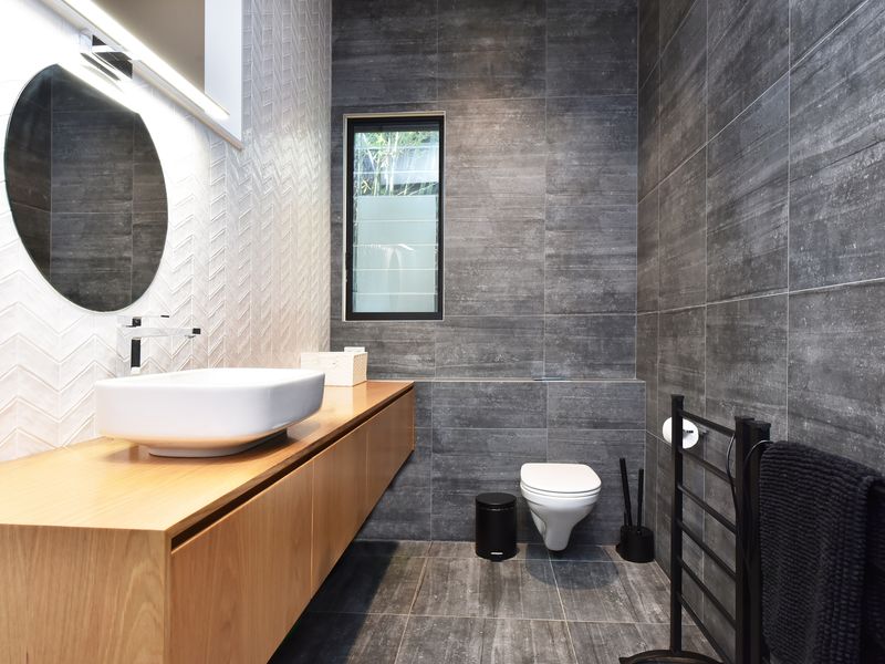 Bathroom vanity shot showing textured tile detail and window.